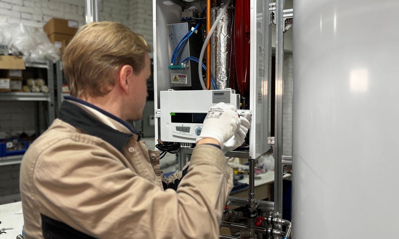 Technician adjusting the controls of a water heater installation